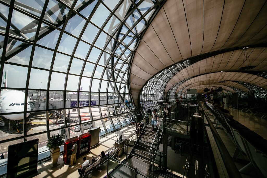 Bright modern airport terminal hall with a curved glass roof