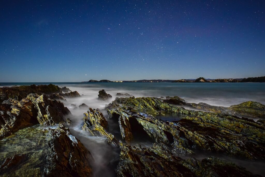 Clear night sky over a remote coast, ideal for stargazing travel