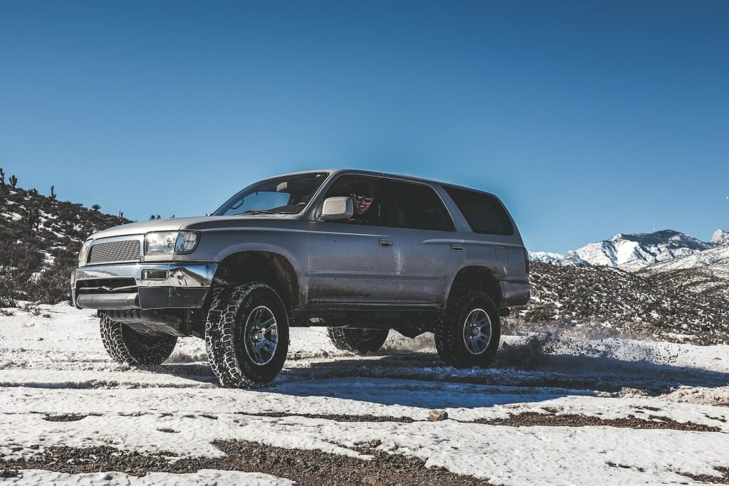 Four-wheel-drive SUV parked on a snowy mountain trail