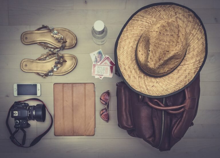 Hat, sandals and bag laid out, showing what to pack for a luxury vacation