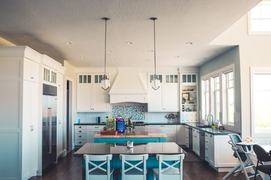 Open plan kitchen with pale cabinetry, pendant lights and a long island