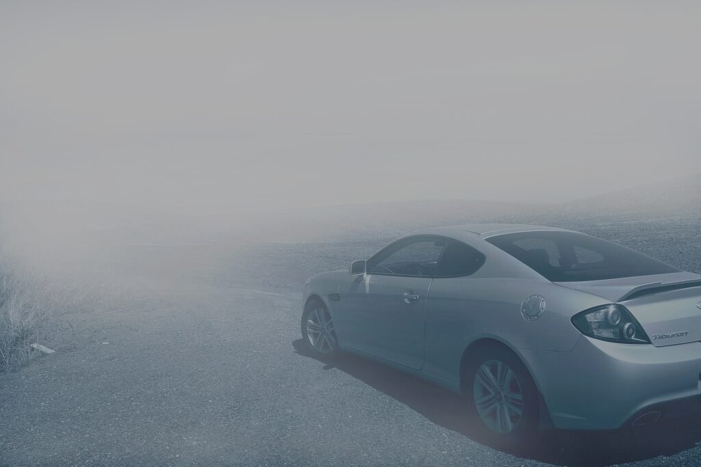 Sleek luxury coupe parked in soft morning fog