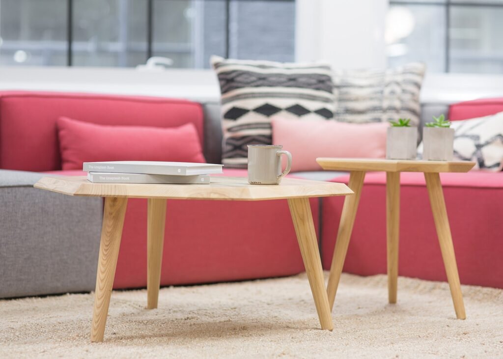 Soft sofa with cushions and two wooden coffee tables in a calm living room