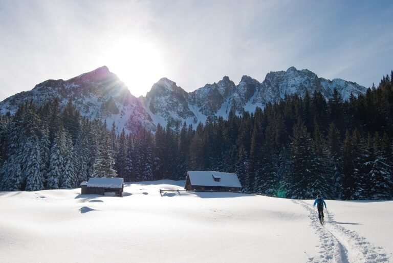 Sunlit snow-capped mountains above alpine chalets in winter