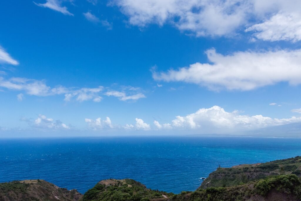 Traveller gazing out over a dramatic coastline and blue sea